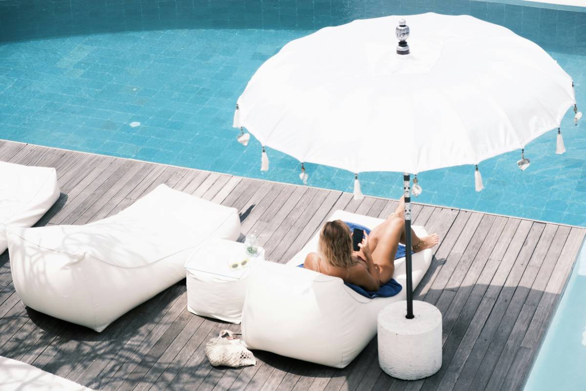 Two high-quality poolside umbrellas australia mounted on reinforced concrete bases beside a turquoise saltwater pool in Brisbane backyard